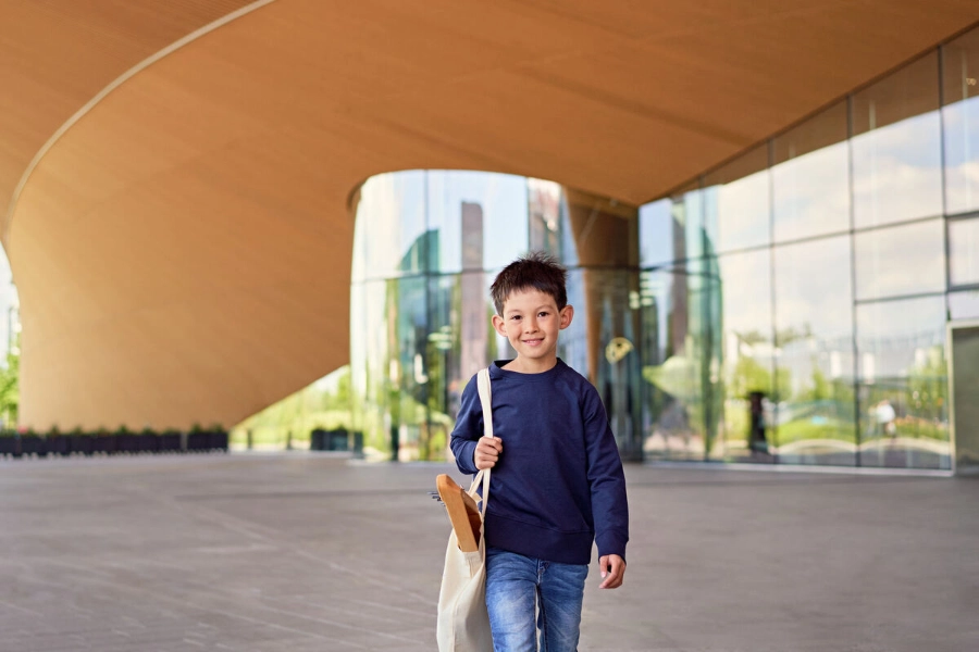 A boy holds a canvas bag of school supplies. - Mikko Törmänen / Keksi Agency