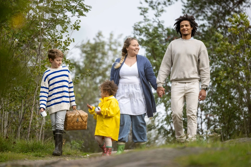 A family walking happily in the forest - Marjaana Malkamäki / Keksi