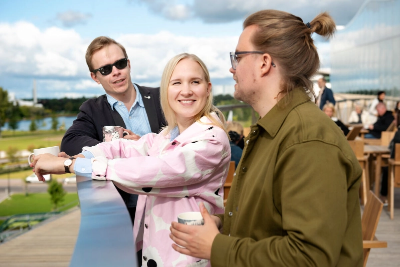 Three colleagues enjoy coffee on an outdoor terrace. - Markus Sommers / Business Finland