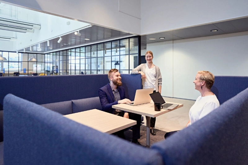 Colleagues meet with their laptops inside a modern office building. - Mikko Törmänen / Keksi Agency