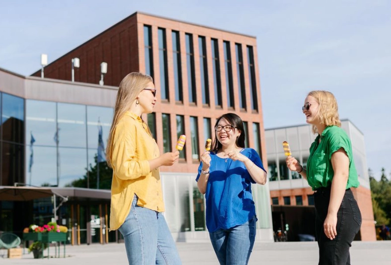 Kolme naista seisovat ulkona jäätelöt kädessään - Aalto Yliopisto / Petri Anttila