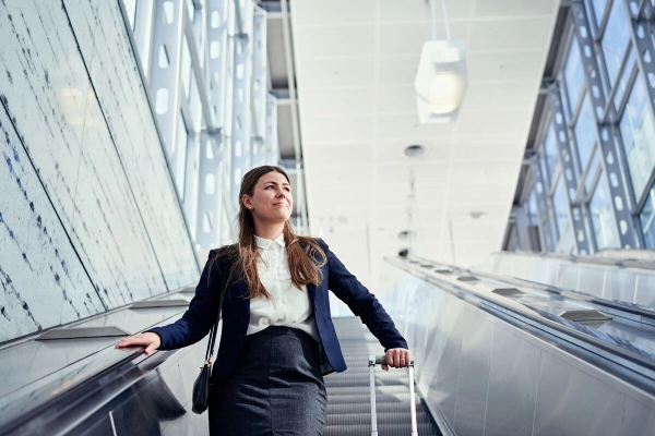 A woman with a suitcase using an escalator. - Mikko Törmänen / Keksi Agency / Business Finland