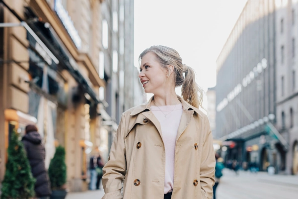 A smiling woman walks on the street. - Work in Finland / Elina Manninen